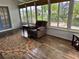 Inviting sunroom featuring a comfortable recliner, wood floors, and natural light from large windows at 2003 Cordero Ct, The Villages, FL 32159
