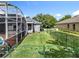 A long narrow backyard with a decorative fence, adjacent to a screened-in pool area at 2024 Meadowside Dr, Eustis, FL 32726