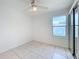 The bedroom has a ceiling fan, a backyard view through the window and tile flooring at 2024 Meadowside Dr, Eustis, FL 32726