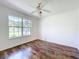 An empty bedroom with a ceiling fan, a large window, and hardwood floors at 2024 Meadowside Dr, Eustis, FL 32726