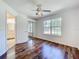 Bedroom features wood flooring, ceiling fan and a window with backyard view at 2024 Meadowside Dr, Eustis, FL 32726