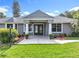 Inviting front entrance of gray home featuring double doors, manicured landscaping, and a well-maintained lawn at 2024 Meadowside Dr, Eustis, FL 32726