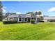 Beautiful single-story home featuring a well-manicured lawn, lush landscaping, and a classic architectural design at 2024 Meadowside Dr, Eustis, FL 32726