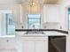 Kitchen sink with white cabinets and view to pool area at 2024 Meadowside Dr, Eustis, FL 32726