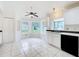 Bright eat-in kitchen features white cabinetry, tile floors, a large bay window, and modern black appliances at 2024 Meadowside Dr, Eustis, FL 32726