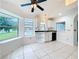 Bright eat-in kitchen with white cabinets, tile floor and view to pool at 2024 Meadowside Dr, Eustis, FL 32726