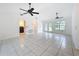 Open-concept living room featuring tile floors, ceiling fans, and access to a laundry room and outdoor patio at 2024 Meadowside Dr, Eustis, FL 32726