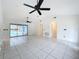 Spacious living room with tile flooring, high ceilings, and ceiling fans, offering access to the outdoor pool area at 2024 Meadowside Dr, Eustis, FL 32726