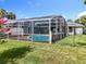View of a screened in pool, surrounded by a green lawn and decorative fence at 2024 Meadowside Dr, Eustis, FL 32726