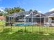 Screened in pool with a well manicured lawn and a decorative fence surrounding the pool area at 2024 Meadowside Dr, Eustis, FL 32726