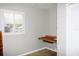 Neutral-toned bedroom featuring a built-in desk and a large window with shutter blinds at 23515 Poinsettia Ave, Fruitland Park, FL 34731