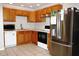 Well-lit kitchen features wooden cabinetry, stainless steel appliances, and neutral countertops at 23515 Poinsettia Ave, Fruitland Park, FL 34731