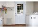 White laundry appliances, shelving, and an exterior door enhance functionality at 23515 Poinsettia Ave, Fruitland Park, FL 34731