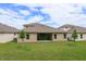 Expansive backyard featuring lush green grass, landscaping, and a covered patio at 2364 Juniper Berry Dr, Minneola, FL 34715