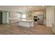 Well-lit kitchen features white cabinets, island, and stainless steel appliances at 2364 Juniper Berry Dr, Minneola, FL 34715