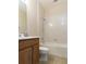 Bathroom with wood vanity, ceramic tile flooring, bath tub and shower combination at 245 Blue Cypress Dr, Groveland, FL 34736