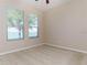 Cozy bedroom with large windows providing natural light, carpeted floor, and ceiling fan at 245 Blue Cypress Dr, Groveland, FL 34736