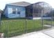 Exterior view of the home featuring a screened-in patio and fenced yard at 245 Blue Cypress Dr, Groveland, FL 34736