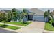 Charming single-story home featuring a well-maintained lawn, lush landscaping, and a two-car garage at 245 Blue Cypress Dr, Groveland, FL 34736