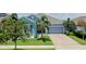 Charming single-story home featuring a well-maintained lawn, lush landscaping, and a two-car garage at 245 Blue Cypress Dr, Groveland, FL 34736