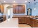 Well-lit kitchen featuring tile flooring, light countertops, wood cabinets and stainless steel appliances at 245 Blue Cypress Dr, Groveland, FL 34736