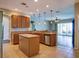 Modern kitchen with an island, stainless steel appliances, and tile flooring, ideal for cooking and entertaining at 245 Blue Cypress Dr, Groveland, FL 34736