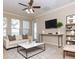 Bright living room featuring large windows, ceiling fan, and stylish decor at 245 Blue Cypress Dr, Groveland, FL 34736