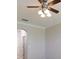 Cozy living room features an arched doorway, neutral paint, white crown molding, and ceiling fan at 245 Blue Cypress Dr, Groveland, FL 34736