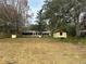 Large backyard with mature trees, the house and an outbuilding at 24892 Sw Sailboat Dr, Dunnellon, FL 34431