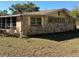 Stone facade accented by shuttered windows and an enclosed porch at 24892 Sw Sailboat Dr, Dunnellon, FL 34431