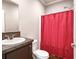 Cozy bathroom with granite countertops, tile floor, and a shower with a bright red curtain at 25156 Buttonwood Dr # 126, Astatula, FL 34705