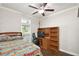 Bedroom featuring a cozy bed, desk, chair, and hardwood floors, offering a comfortable and functional space at 25156 Buttonwood Dr # 126, Astatula, FL 34705