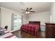 Bedroom features a buffalo-check blanket, ceiling fan and a window providing natural light at 25156 Buttonwood Dr # 126, Astatula, FL 34705