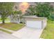 Single-story home featuring an attached two-car garage, concrete driveway, and well-maintained lawn at 25156 Buttonwood Dr # 126, Astatula, FL 34705