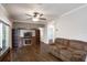 Cozy living room with hardwood floors, ceiling fan, and a large entertainment center with storage and display space at 25156 Buttonwood Dr # 126, Astatula, FL 34705