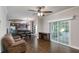 Open-concept living room and kitchen with dark wood floors and a sliding glass door leading to the outside at 25156 Buttonwood Dr # 126, Astatula, FL 34705