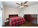 Main bedroom features a buffalo-check blanket, ceiling fan and en suite bathroom at 25156 Buttonwood Dr # 126, Astatula, FL 34705