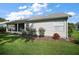 View of the backyard of the house featuring a screened lanai and green grass at 25406 Crestwater Dr, Leesburg, FL 34748
