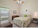 Cozy bedroom with a floral bedspread, a ceiling fan, and soft lighting, providing a restful environment at 25406 Crestwater Dr, Leesburg, FL 34748