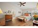 Inviting bedroom with wood floors, a ceiling fan, and an ensuite bathroom, providing a comfortable retreat at 25406 Crestwater Dr, Leesburg, FL 34748