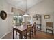 Dining room with wood floors, table with seating for six, and view of the yard at 25406 Crestwater Dr, Leesburg, FL 34748