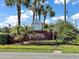The Plantation at Leesburg entrance sign features a brick base, white lettering, and palm tree landscaping at 25406 Crestwater Dr, Leesburg, FL 34748