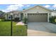 Charming single-story home with a well-maintained lawn, attached two-car garage and mature landscaping at 25406 Crestwater Dr, Leesburg, FL 34748