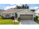 Charming single-story home with a well-maintained lawn, attached two-car garage and mature landscaping at 25406 Crestwater Dr, Leesburg, FL 34748