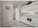Bright kitchen features white cabinets, appliances, ample counter space, and tiled floor at 25406 Crestwater Dr, Leesburg, FL 34748