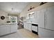 Bright kitchen with white cabinetry, island, and breakfast bar; opens to dining area at 25406 Crestwater Dr, Leesburg, FL 34748