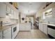 White kitchen features modern appliances, ample cabinetry, island, and open layout to dining area at 25406 Crestwater Dr, Leesburg, FL 34748