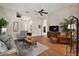 Inviting living room boasts wood floors, comfortable seating, ceiling fan, and stylish decor at 25406 Crestwater Dr, Leesburg, FL 34748