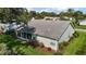 View of the back of the house featuring a screened lanai and green grass at 25406 Crestwater Dr, Leesburg, FL 34748