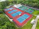 Aerial view of multiple tennis courts and a clubhouse surrounded by mature trees at 25406 Crestwater Dr, Leesburg, FL 34748